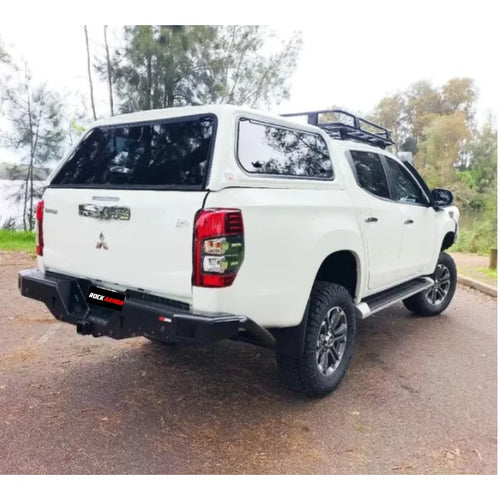 White Mitsubishi pickup truck rear fitted with rockarmor elite rear steel checker plate step and high lift jack mount