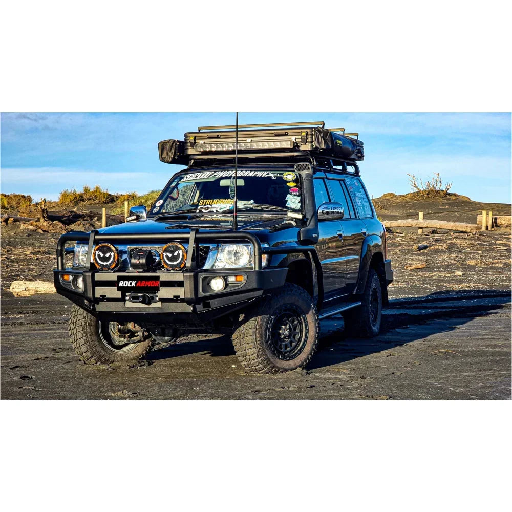 Black nissan patrol gu1 off-road vehicle equipped with rockarmor brushbar and roof rack for premium protection