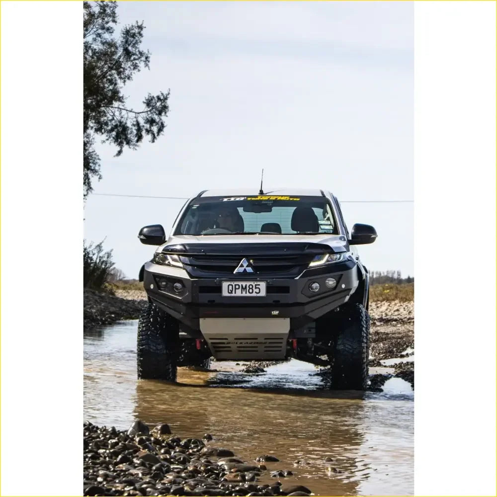 Black mitsubishi triton pickup with gt hoopless bullbar and rock sliders from rockarmor rock pack for off-road use