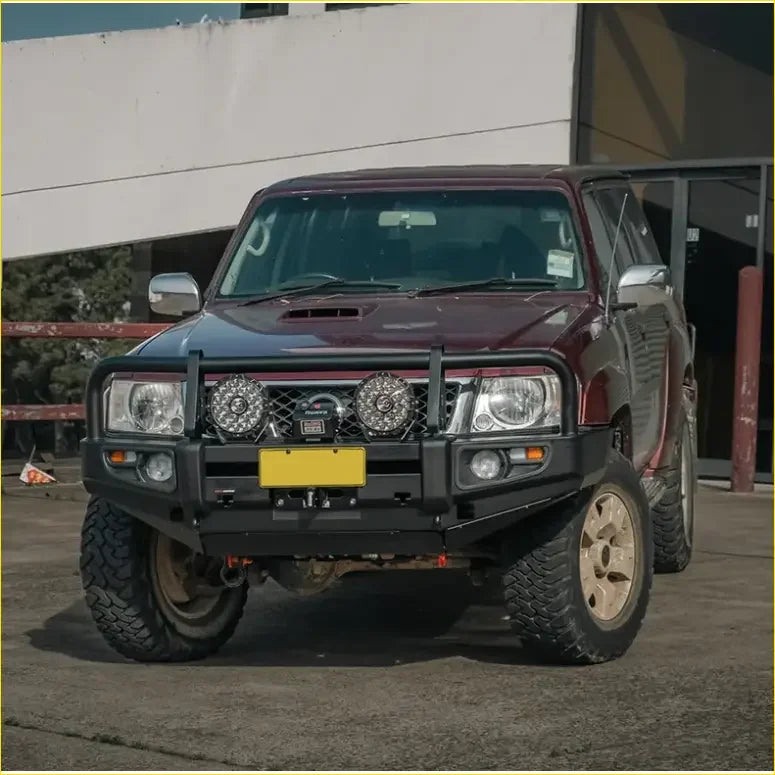Maroon Nissan Patrol with black rockarmor premium bullbar and rugged off-road tires for GU4 2005 to current models