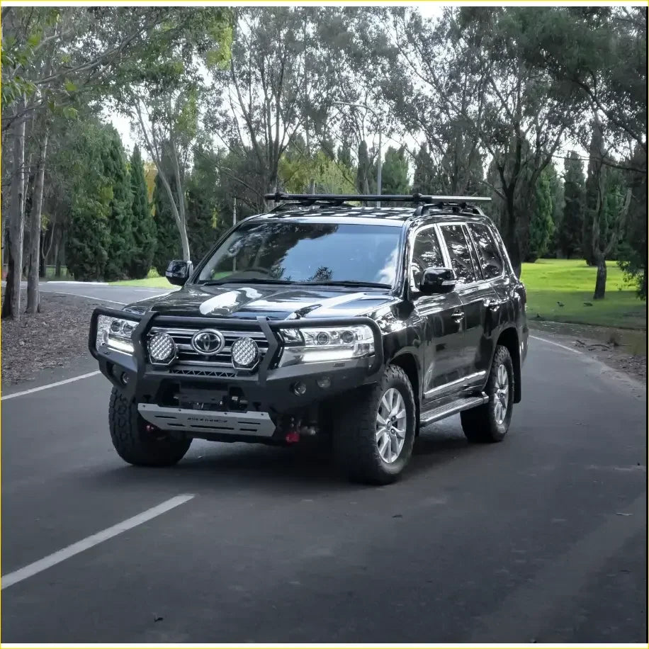 Black toyota land cruiser 300 with rockarmor gt hoop bullbar and rock sliders rugged front bumper and roof rack