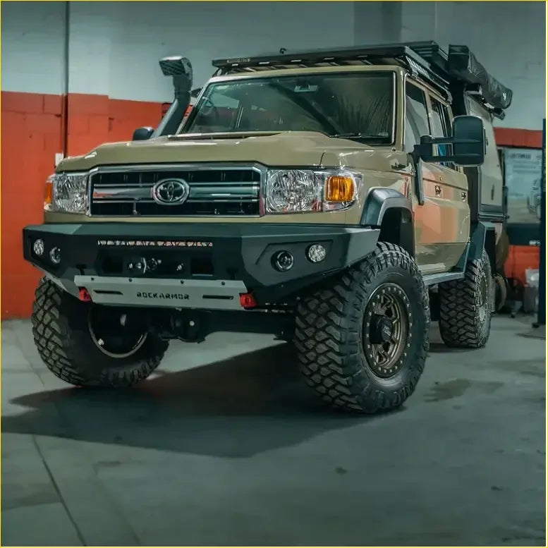 Tan toyota land cruiser 70 with black rockarmor front bumper rugged off-road tires from rockarmor rock pack for toyota 79