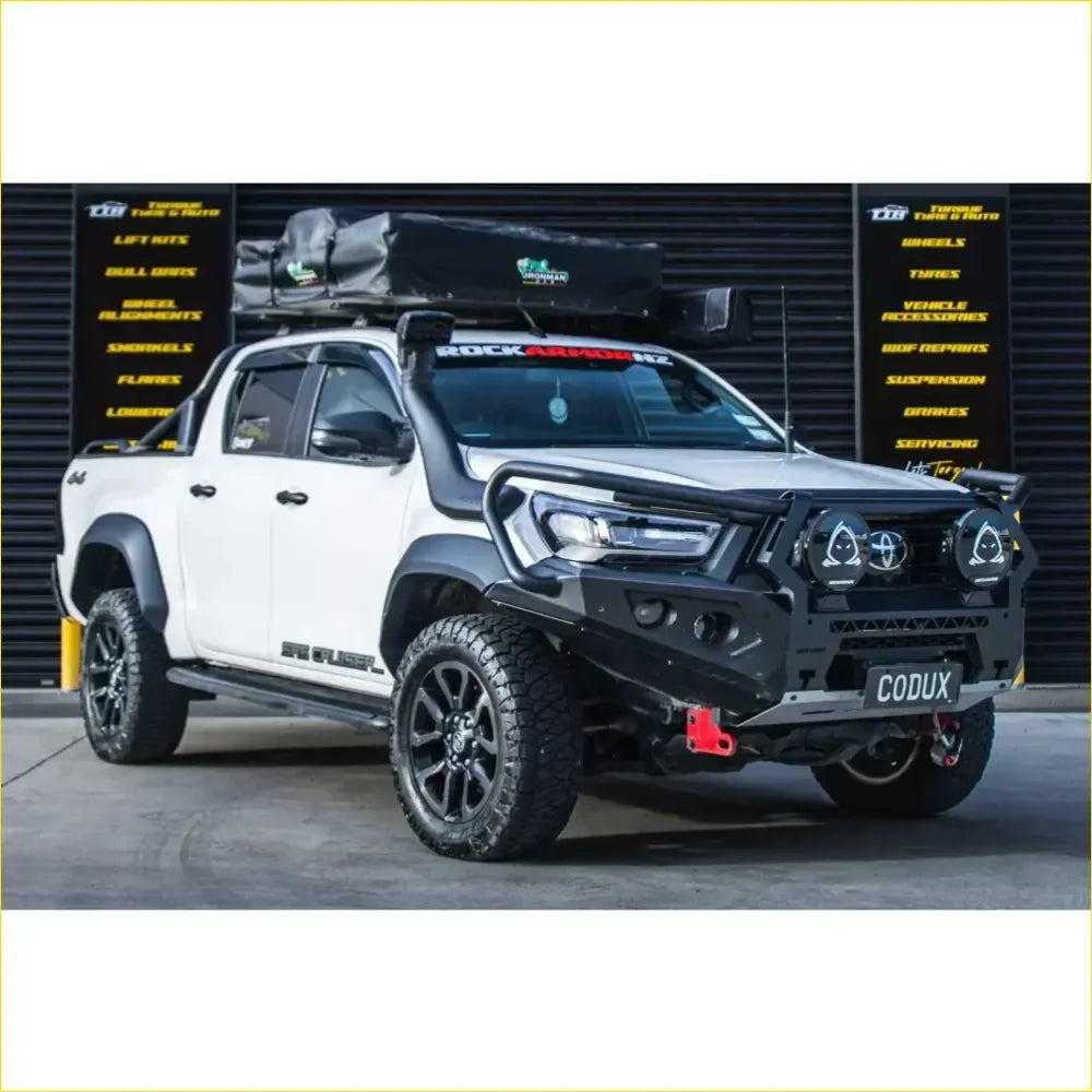 White toyota hilux 2022 widebody with black gt hoop bullbar roof rack and rock sliders off-road accessories
