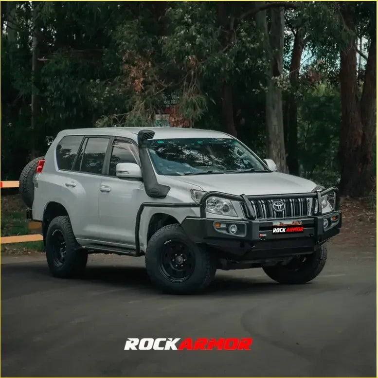 Silver toyota land cruiser prado with black rockarmor front bumper and off-road rock sliders from rock pack
