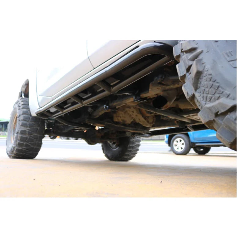 Truck undercarriage with oversized tires showcasing rockarmor steel rockslider side steps for nissan patrol y61 gu1 gu4